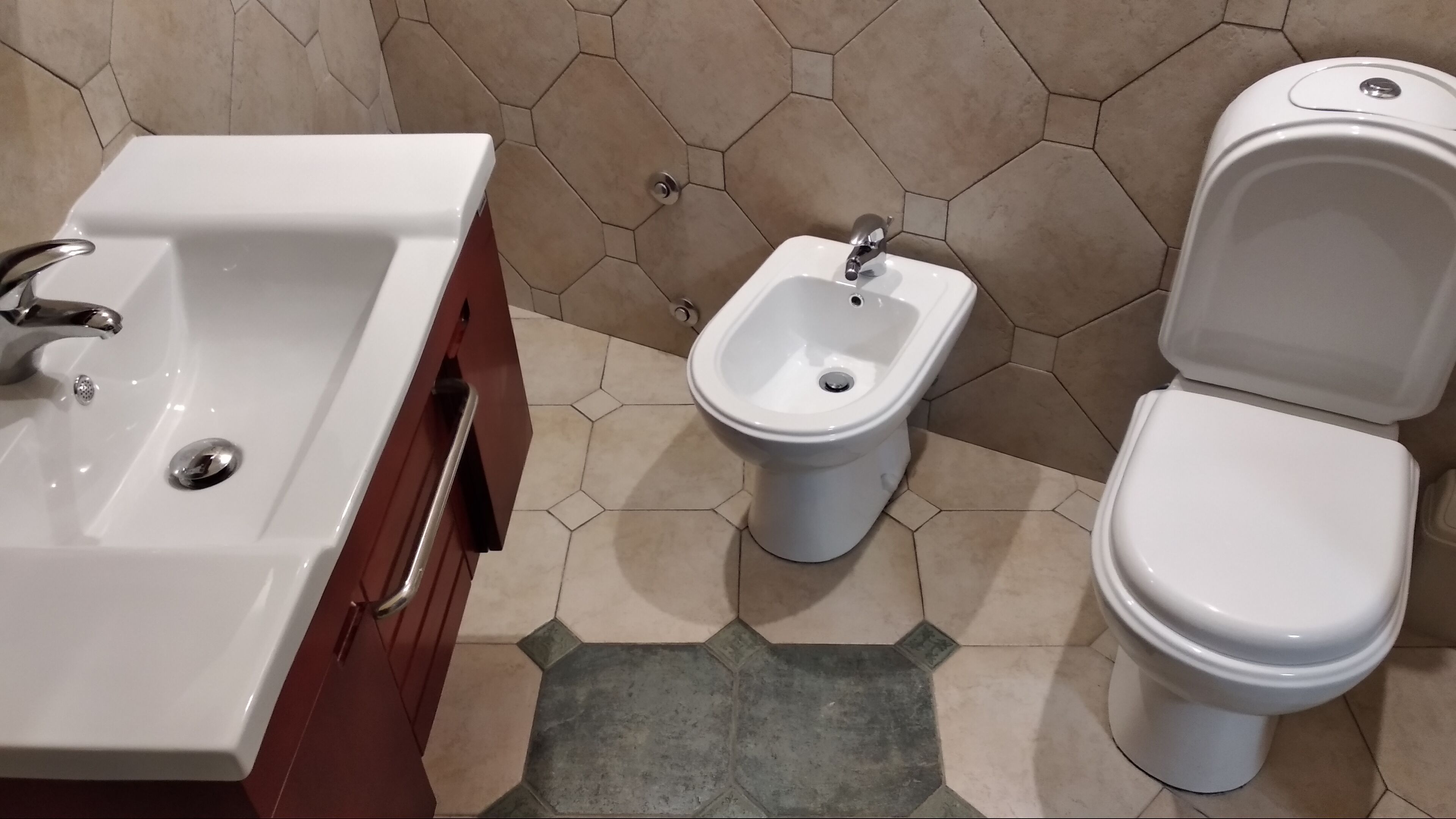 A bathroom with a white sink, bidet, and toilet.
