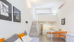 Eine moderne Wohnung mit Wohnbereich, Küche und einer Treppe.