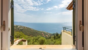 A view from a balcony overlooking a coastal landscape with a clear sky.
