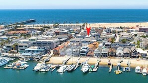 A coastal town with a marina, beachfront, and residential buildings. - Newport Beach Modern Home steps to the Beach (Newport Beach)