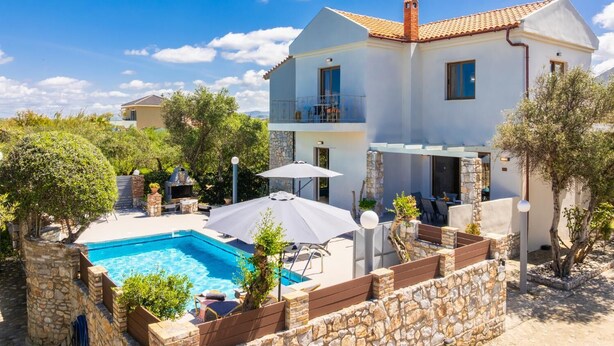 A two-story house with a swimming pool, outdoor seating, and a stone wall surrounding the property. - Villa Tzina - Three Bedroom Villa, Sleeps 6 (Tavronitis)
