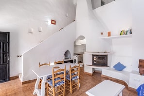 A modern interior with a dining area, kitchen, and fireplace.