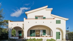 A two-story building with a white facade, green shutters, and a balcony. - Villa Asteria directly on the beach (Campo nell'Elba)