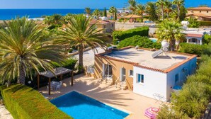 Una propiedad residencial con piscina, un porche cubierto y vista al mar.