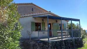 A house with a stone foundation, a covered porch, and a small tree in the foreground. - Le Vignal 2, cottage with 2 bedrooms in the south of the Ardèche (Chambonas)