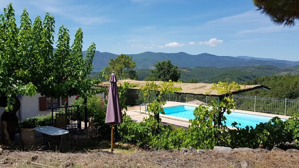 A pool area with a view of mountains, surrounded by greenery and a pergola. - Le Vignal 2, cottage with 2 bedrooms in the south of the Ardèche (Chambonas)