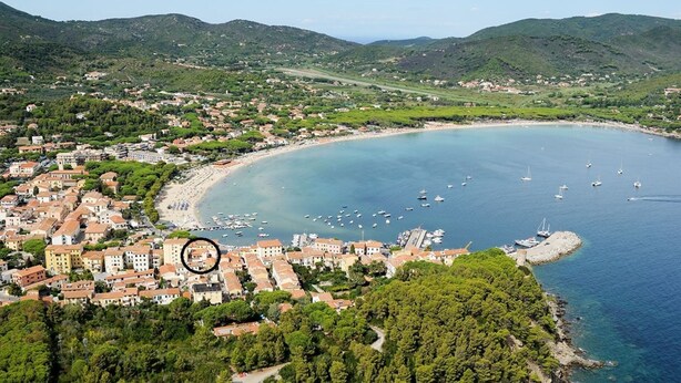 Un pueblo costero con una bahía, barcos y edificios.