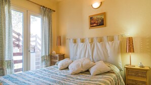 Un dormitorio con una cama grande, una mesita de noche, una lámpara y un cuadro en la pared.