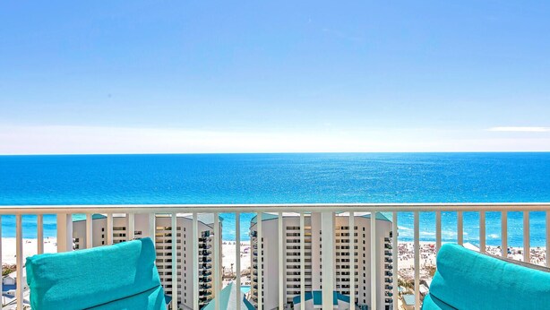 A balcony with a view of the ocean and beach.