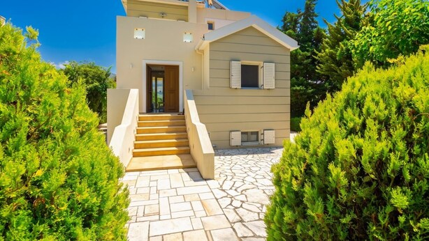 A two-story house with a stone staircase leading to the entrance.