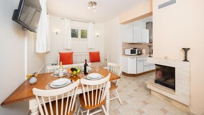 A modern kitchen with white cabinets, a built-in microwave, and a fireplace.