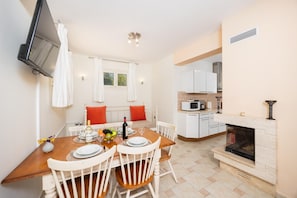 A modern kitchen with white cabinets, a built-in microwave, and a fireplace. - Villa Semeli - Two Bedroom Villa, Sleeps 5 (Ionian Islands)