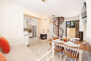 Un intérieur moderne comprenant un coin repas, une cuisine et un escalier en colimaçon.