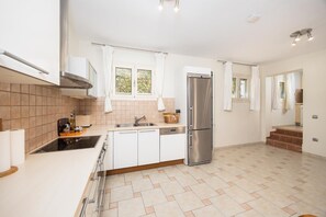 A modern kitchen with a stainless steel refrigerator, white cabinets, and a tiled floor. - Villa Semeli - Two Bedroom Villa, Sleeps 5 (Ionian Islands)
