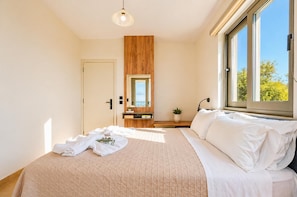 Quarto com cama, mesa de cabeceira, espelho, janela e porta.