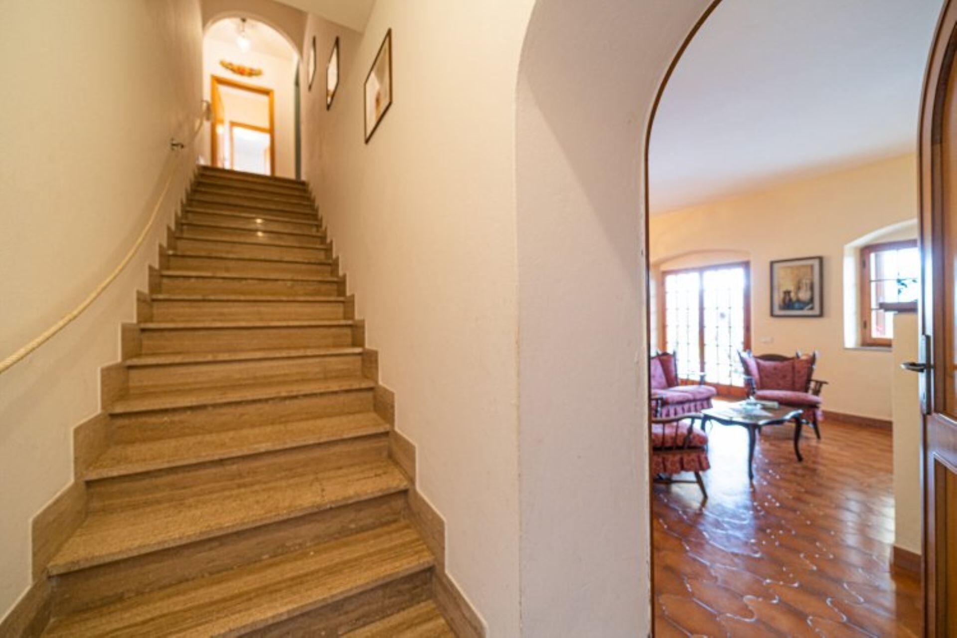 A wooden staircase leading to a living room with a sofa and a coffee table.