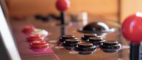 A close-up of a joystick control panel with red and black buttons.