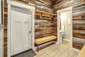 Enjoy a refreshing bath in the bathroom, featuring a wooden bench, sink, and door.