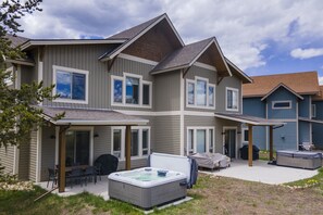Enjoy a relaxing getaway with a covered patio featuring a hot tub, outdoor seating, and barbecue grill.