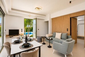 Una sala de estar moderna con una mesa de comedor, sofá y televisor.