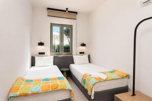 Una habitación de hotel con dos camas, una ventana y una mesita.
