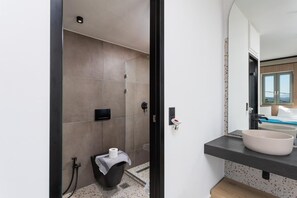 Un baño moderno con ducha, inodoro y dos lavamanos.
