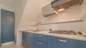 A kitchen with blue cabinets, a white countertop, and a gas stove. - Studio 4 with sea view pool in a panoramic position above the village of Porto Azzurro (Porto Azzurro)