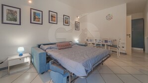 A modern bedroom with a bed, bedside table, lamp, and a desk with a chair. - Studio 4 with sea view pool in a panoramic position above the village of Porto Azzurro (Porto Azzurro)