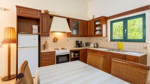 Una cocina compacta con armarios de madera, un refrigerador blanco, estufa, microondas y un lavaplatos.