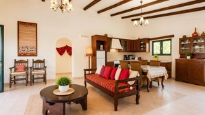 Una sala de estar con sofá, sillas, una mesita de centro y un comedor con mesa y sillas.