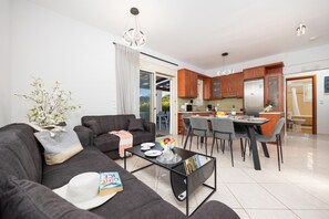 Ein modernes Wohnzimmer mit Sofa, Couchtisch und Essbereich.