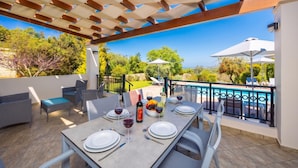 An outdoor dining area with a table set for two, a pool, and a view of the landscape. - Villa Georgia - Three Bedroom Villa, Sleeps 6 (Crete)