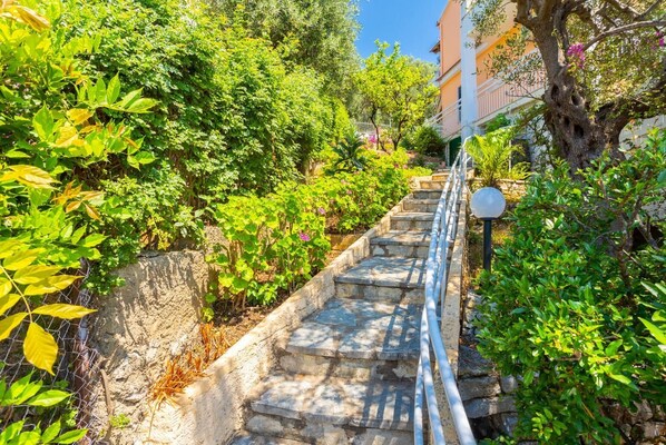 A stone staircase with a metal handrail leading up to a building.