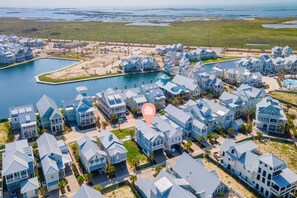 Zona residencial costera con casas, un puerto deportivo y una gran masa de agua.