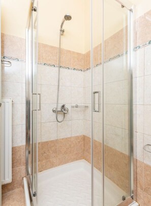 A glass-enclosed shower stall with a handheld showerhead and a wall-mounted faucet. - Villa Russa Dionisis (Afrato)