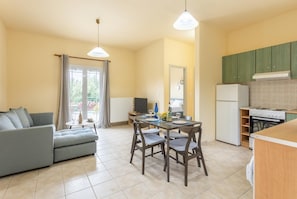Un espacio habitable pequeño con comedor, kitchenette y sofá.