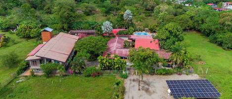 An aerial view of a residential area with houses, a swimming pool, and solar panels.