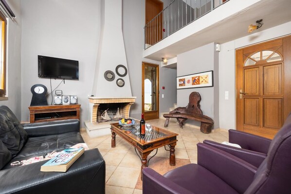 A living room with a fireplace, a television, and a sofa.