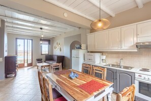 Una cocina amplia con armarios blancos, una mesa de comedor de madera y una isla grande.