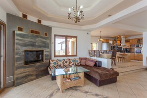 A spacious living area with a modern sofa, a glass coffee table, and a fireplace.