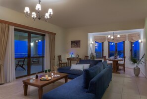 Un salon moderne comprenant un ensemble de canapés, une table à manger et un balcon avec vue.