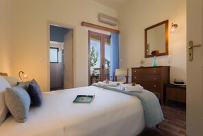 Ett hotellrum med en säng, en byrå, en spegel, en lampa och utsikt över omgivningarna.