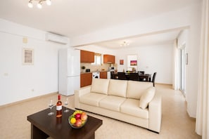 A modern apartment with a living room, kitchen, and dining area.