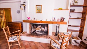Ein gemütliches Wohnzimmer mit Kamin, Holzmöbeln und einer Bücherwand.