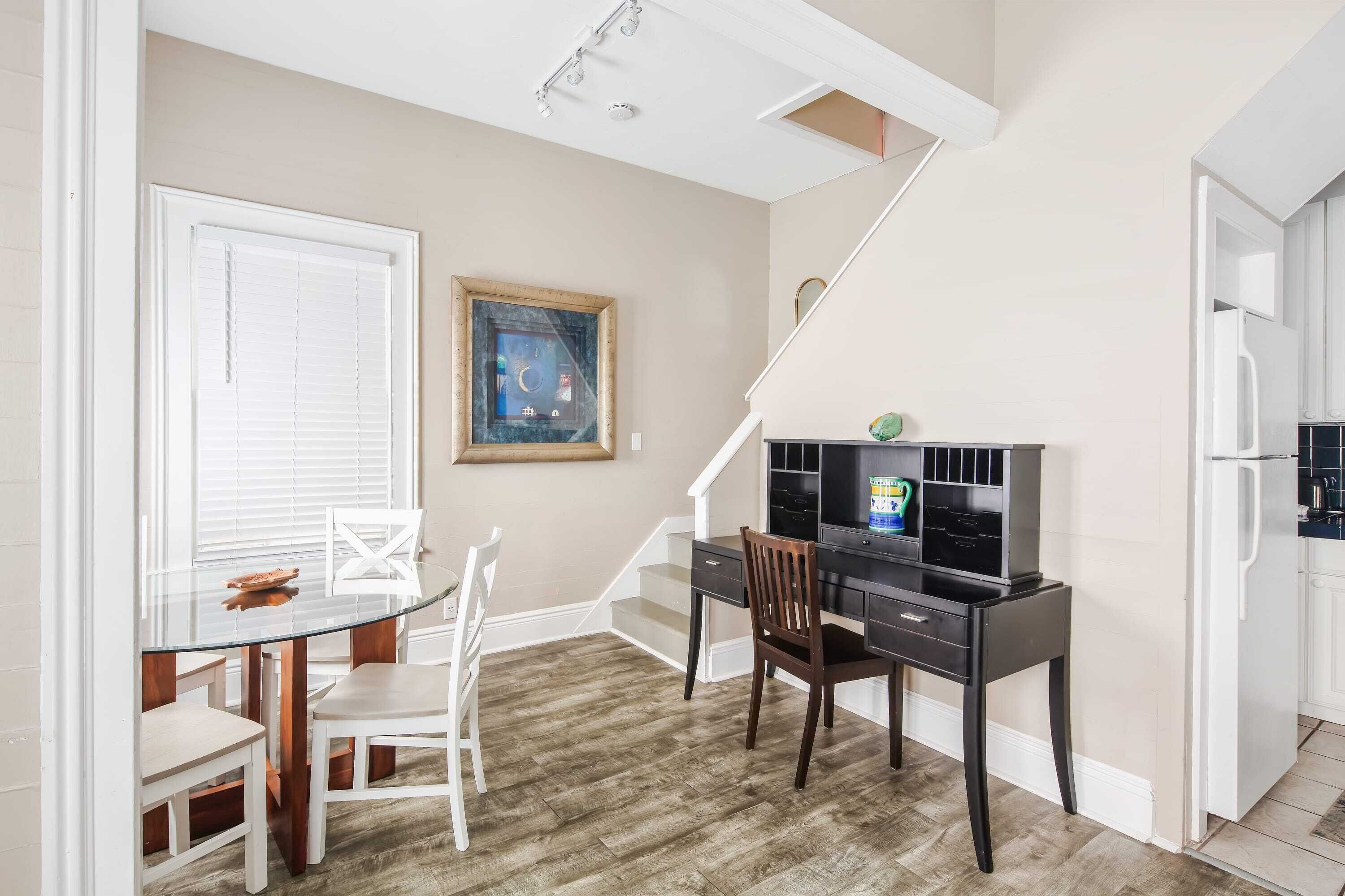 A compact living space with a dining area, a desk, and a kitchen.