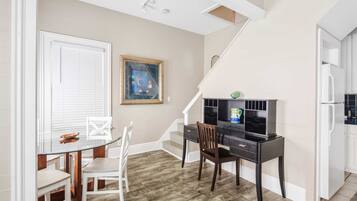 A compact living space with a dining area, a desk, and a kitchen.