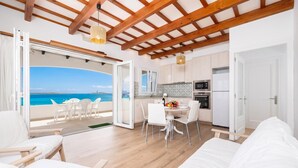 Un intérieur moderne avec un balcon, des meubles blancs et un coin cuisine.