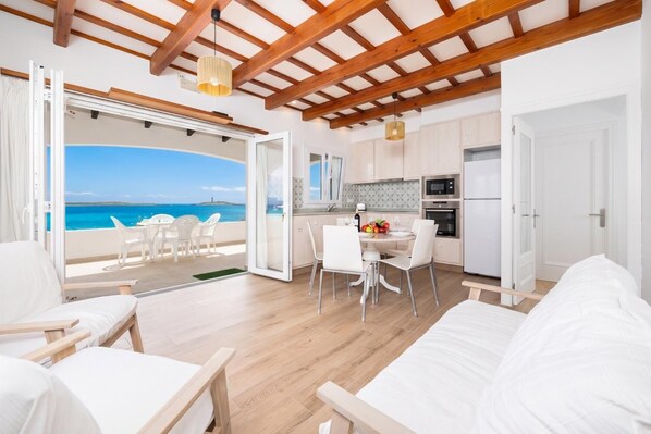 Un intérieur moderne avec un balcon, des meubles blancs et un coin cuisine.