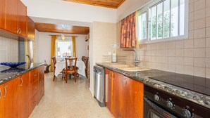 A modern kitchen with wooden cabinets, a granite countertop, a dishwasher, and a stove. - Villa Constantinos - Three Bedroom Villa, Sleeps 6 (Agia Marina Chrysochous)