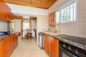 Una cocina moderna con armarios de madera, encimera de granito, lavavajillas y estufa.